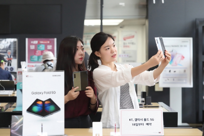  KT가 18일부터 25일까지 8일간 전국 KT 매장 및 공식 온라인채널 KT샵에서 삼성전자 ‘갤럭시 폴드 5G’ 예약을 진행한다고 밝혔다. 예약 고객은 26일부터 개통할 수 있다.사진은 모델들이 갤럭시 폴드를 직접 체험하고 있다.  
