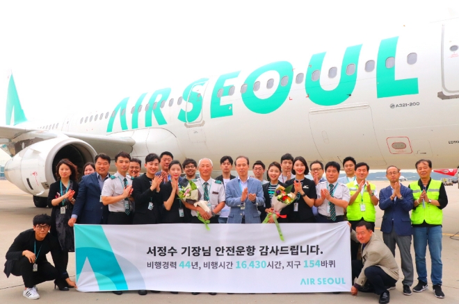 에어서울 서정수 기장이 마지막 비행을 마치고 임직원들과 기념 촬영을 하고 있다