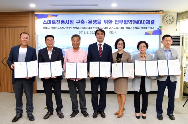 사진 좌측부터 하남시 (시장 김상호), ㈜케이포스트(대표이사 신기선), 한국우편사업진흥원 (실장 김용진), 대한주택관리사협회 경기도회(회장 이선미),덕풍전통시장 상인회(회장 김재근), 신장전통시장 상인회(회장 여봉열), 석바대상점가(회장 하홍모)