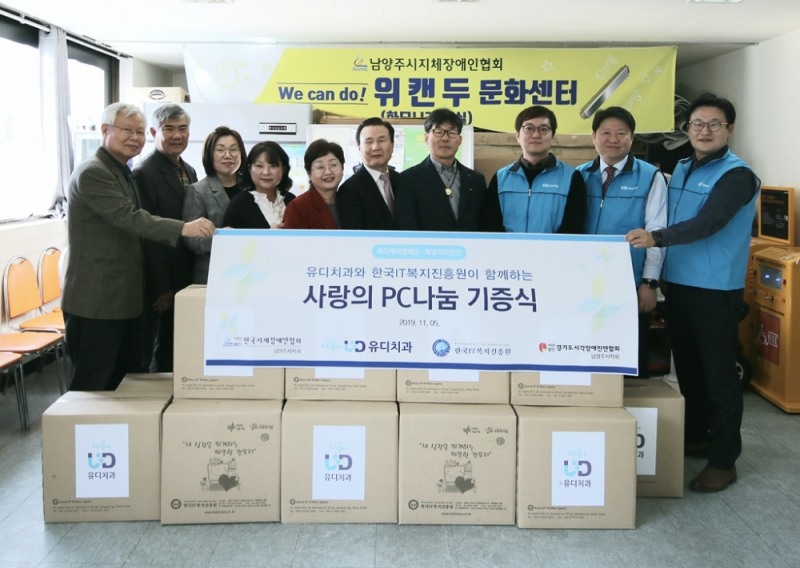 사진설명 –왼쪽부터 허완 한국IT복지진흥원 사무총장, 손정선 한국농아인협회 남양주시지회장, 정미경 한국IT복지진흥원 사무국장, 임정임 남양주시청 장애인복지과장, 전명희 한국장애인정보화협회 남양주시지회장, 임재남 경기도시각장애인연합회 남양주시지회장, 최만석 한국지체장애인협회 남양주시지회장, 고광욱 (주)유디 대표이사(파주 유디치과의원 대표원장), 김종명 (주)유디 사장, 이경환 (주)유디 홍보기획팀장이 ‘사랑의 PC’ 전달식을 기념해 포즈를 취하고 있다.