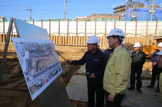 명현관 해남군수와 군 관계자들이 지난 11일 청사신축사업 현장에서 공정설명을 듣고, 점검을 실시하고 있다./사진=해남군