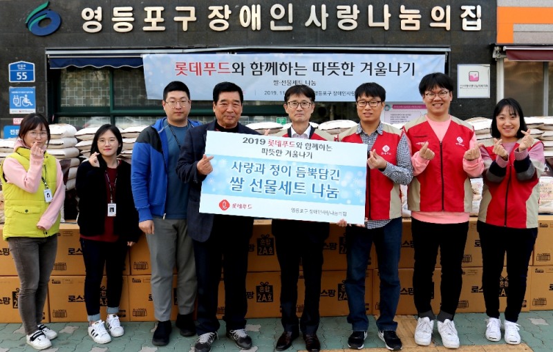 27일 서울 영등포구 장애인 사랑 나눔의 집에서 롯데푸드 권기정 경영지원부문장(왼쪽에서 다섯 번째)과 샤롯데봉사단이 영등포구 장애인 사랑 나눔의 집 김금상 회장(왼쪽에서 네 번째)에게 영등포구 저소득층 장애인 200가구에 지원할 쌀과 로스팜 세트를 전달하고 있다.