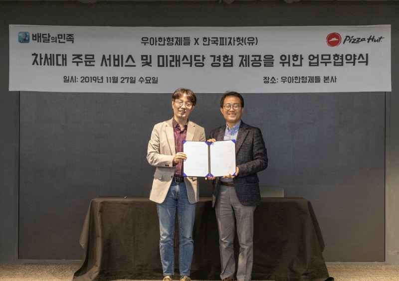 26일 진행된 한국피자헛과 우아한형제들의 업무협약식에서 한국피자헛 김명환 대표(오른쪽)와 우아한형제들 김범준 부사장(왼쪽)이기념촬영을 하고 있다.