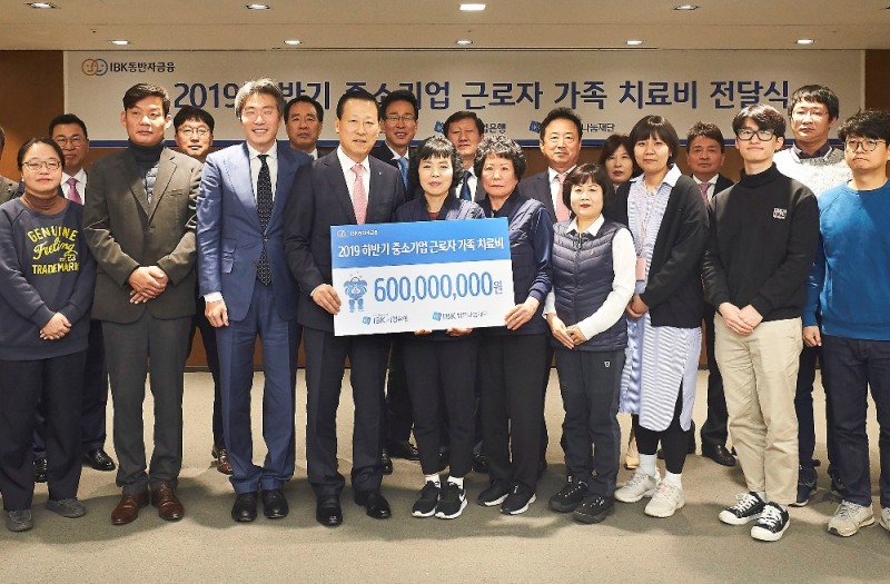 9일 을지로 기업은행 본점에서 김도진 은행장(앞줄 왼쪽 네 번째)과 중소기업 근로자 가족들이 치료비 전달식을 마치고 기념촬영을 하고 있다.