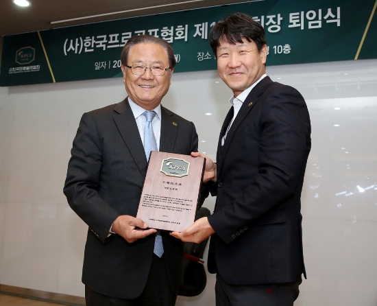 KPGA 김성철 운영팀장(우)에게 KPGA 임직원들이 준비한 재직기념패를 전달받은 KPGA 제17대 양휘부 회장. 사진=KPGA제공