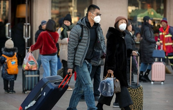 20일(현지시간) 중국 베이징의 베이징 철도역 앞에 여행객들이 마스크를 쓰고 이동하고 있다.