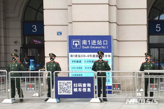  폐렴사태로 봉쇄령이 내려진 23일 중국 우한에서 경찰들이 폐쇄된 기차역 앞을 지키고 있다. 