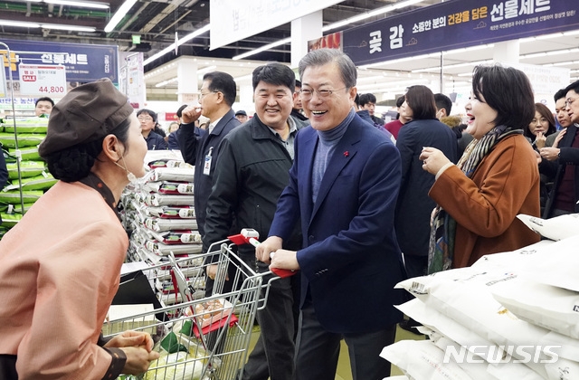 문재인 대통령과 김정숙 여사가 설 명절을 앞둔 23일 서울 서초구 양재동 농협 농수산물유통센터에서 장을 보며 직원과 이야기를 나누고 있다.