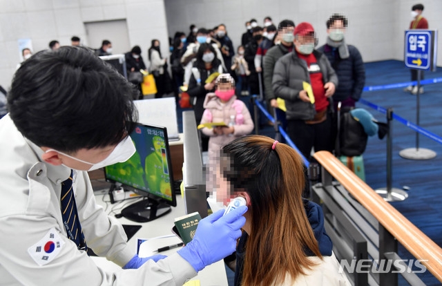 '우한 폐렴'(신종 코로나바이러스 감염증) 확산 우려가 제기되고 있는 28일 부산 강서구 김해국제공항 국제선 입국장에서 중국발 항공기를 타고 온 승객들이 체온 감지 열화상카메라가 설치된 검역대를 지나고 있다. 질병관리본부는 우한 폐렴 국내 확산을 방지하기 위해 중국발 입국자를 대상으로 검역과 건강상태질문서 제출을 의무화 했다.