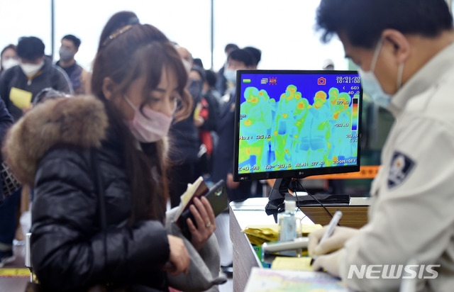질병관리본부가 중국 전역 입국자에 대해 전수검사와 건강 상태 질문서 제출을 의무화한 28일 오전 대구국제공항 국제선 입국장에서 마스크를 쓴 상하이발(發) 비행기 탑승객들이 체온 감지 열화상카메라 검역대를 통과하고 있다.