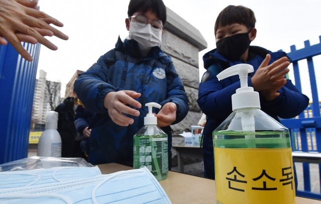 신종 코로나바이러스 감염증(우한 폐렴) 확산 우려가 커지는 가운데 29일 오전 경기 수원시 한 초등학교 학생들이 호흡기 질병 예방을 위해 마스크 착용과  손소독제를 바르며 등교하고 있다.