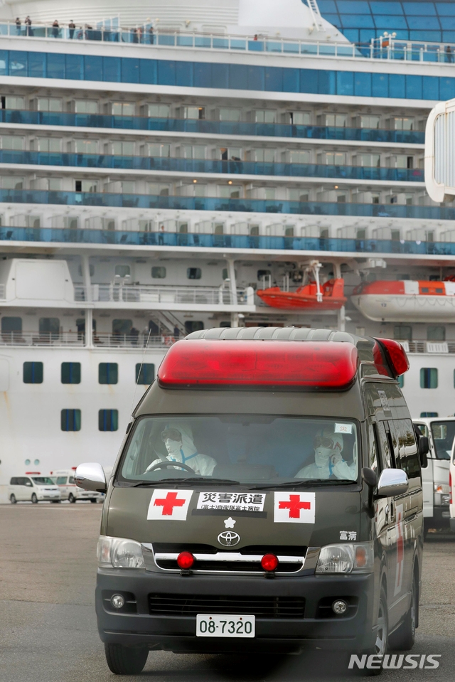 14일 유람선 다이아몬드 프린세스호가 정박 중인 일본 도쿄 인근 요코하마항에서 구급차 한 대가 나오고 있다.