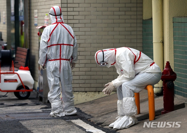 신종 코로나바이러스 감염증(코로나19) 확진자가 무더기로 급증하고 있는 24일 오후 대구 중구 계명대학교 대구동산병원에서 한 방역 관계자가 시설물에 앉아 잠시 휴식을 취하고 있다.
