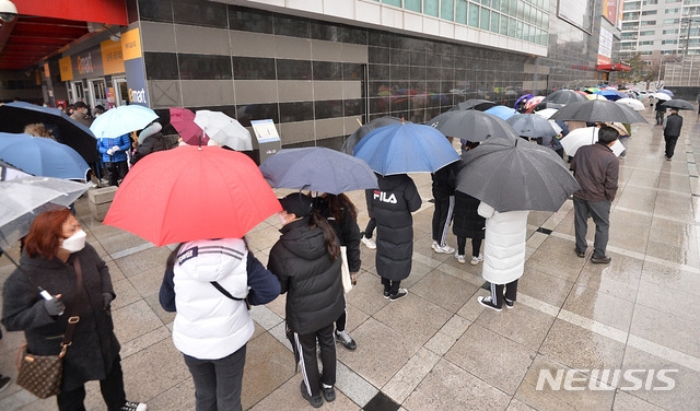 신종 코로나바이러스 감염증(코로나19) 확진자가 무더기로 급증하고 있는 25일 오전 대구 북구 침산동 이마트에서 시민들이 우산을 쓰고 마스크를 구입하기 위해 줄지어 차례를 기다리고 있다./(사진=뉴시스)