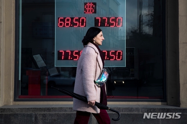 러시아 모스크바에서 지난 9일 한 여성이 미 달러화와 유로화의 러시아 루블 간 환율이 표시된 환전소 전광판 앞을 지나가고 있다. 사우디아라비아와 러시아 간충돌로 유가가 폭락하는 가운데 사우디와 러시아 모두 증산 가능성을 언급해 유가 추가 하락 우려가 커지고 있다.
