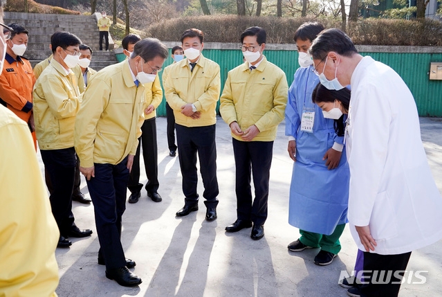 문재인 대통령이 12일 오후 충남 천안에 위치한 충남대구1 생활치료센터에서 운영현황 보고를 받은 뒤 관계자들을 격려하고 있다.
