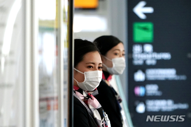 지난 18일(현지시간) 일본 하네다 국제 공항에서 승무원들이 신종 코로나바이러스 감염증(코로나19)을 막기 위해 마스크를 쓴 채 일하고 있다.