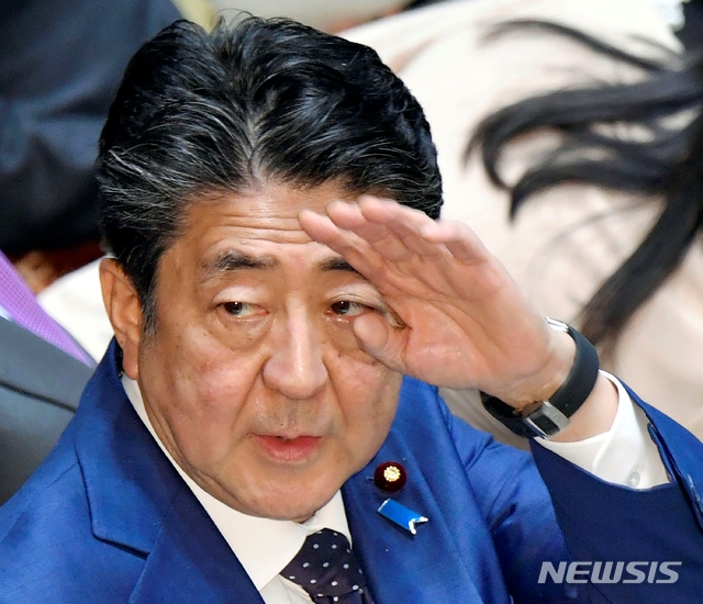 아베 신조 일본 총리가 23일 참의원 예산 위원회에 참석해 손을 들어 인사하고 있다. 아베 총리는 신종 코로나바이러스 감염증 확산으로 2020 도쿄올림픽·패럴림픽을 '완전한 형태'로 실시할 수 없다면 연기할 수도 있다고 밝혔다.