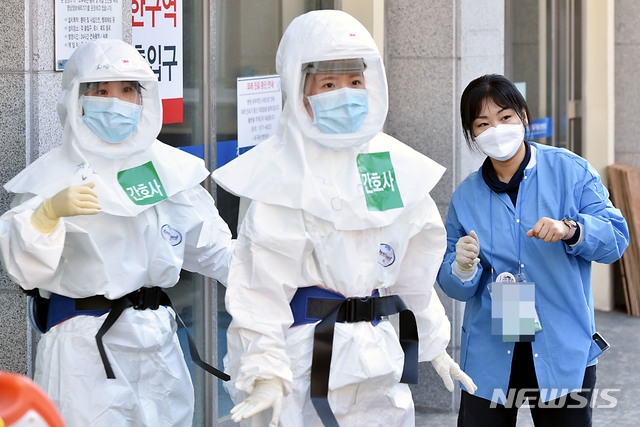 신종 코로나바이러스 감염증(코로나19) 지역거점병원인 18일 오후 대구 중구 계명대학교 대구동산병원에서 의료진이 교대 근무를 위해 방호복을 입고 환자들이 있는 병동으로 향하고 있다.