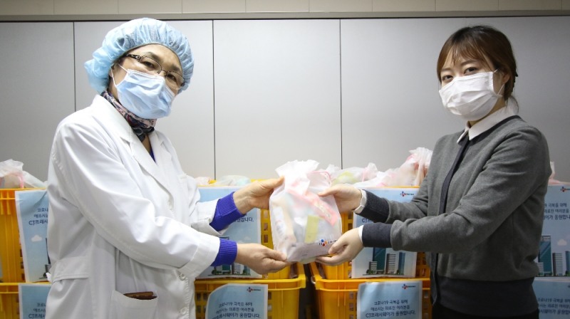 CJ프레시웨이 영양사(사진 오른쪽)가 국립중앙의료원 관계자(사진 왼쪽)에게 구호물품 키트를 전달하고 있다.