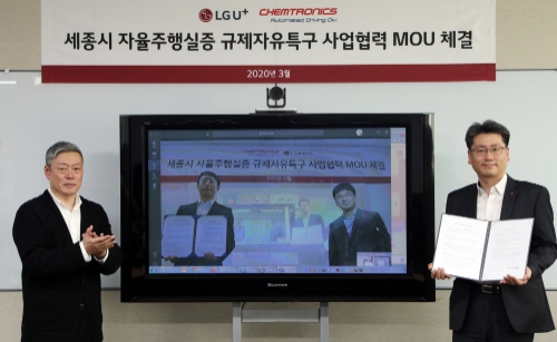 강종오 LG유플러스 모빌리티사업담당 상무(사진 우측)와 김응수 켐트로닉스 자율주행사업부문장 전무(TV속 좌측)가 원격회의를 통해 세종시 자율주행 실증 사업에 대한 업무협약을 맺고 있다. 사진 제공 = LG유플러스
