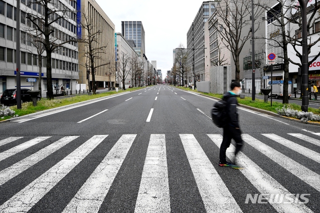 지난 28일 일본 오사카부의 한 텅 빈 거리를 시민이 걸어가고 있다. 오사카부는 코로나19 확산 방지를 위해 외출 자체 요청을 내렸다. 
