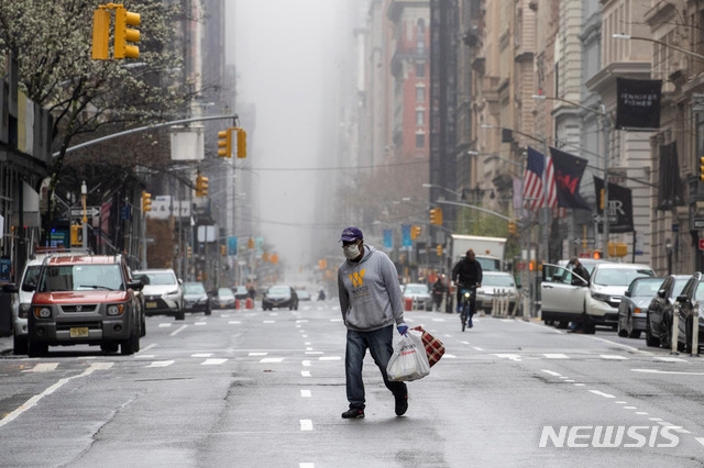 29일 뉴욕 맨해튼에서 한 남성이 마스크를 쓴 채 거리를 걷고 있다.