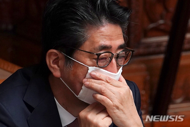 신종 코로나바이러스 감염증 예방을 위해 마스크를 쓴 아베 신조 일본 총리가 3일 일본 도쿄에서 열린 국회 상원 본회의에 참석해 마스크를 매만지고 있다.