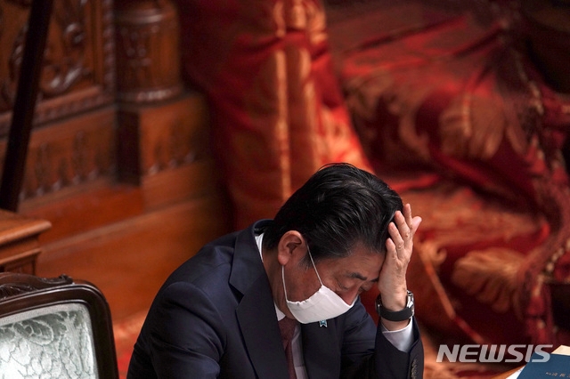 신종 코로나바이러스 감염증 예방을 위해 마스크를 쓴 아베 신조 일본 총리가 3일 일본 도쿄에서 열린 국회 상원 본회의에 참석해 이마를 만지고 있다. 아베 총리는 지난 1일 코로나19 정부 대책 본부 회의에서 가구당 천 마스크 2개를 배포하겠다는 방침을 발표했다가 거센 비난에 직면한 바 있다.