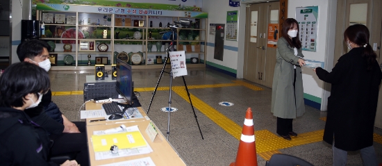 함평군 공무원이 열화상카메라를 통한 검역과 사회적 거리두기 관련 홍보물을 나눠주고 있다./사진=함평군