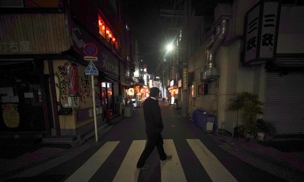 일본 정부가 신종 코로나바이러스 감염증(코로나19) 확산을 막기 위해 '긴급사태 선언'을 발령한 7일 밤 도쿄 신바시의 텅 빈 술집 거리를 한 시민이 걷고 있다.