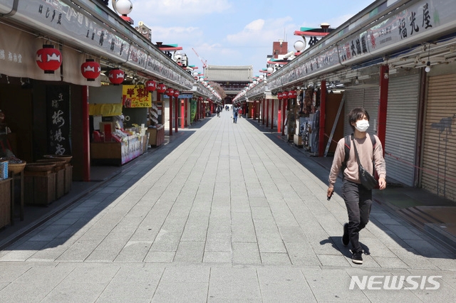 지난 8일 일본 도쿄 아사쿠사의 상점가 '나카미세' 거리가 텅 빈 가운데 한 시민이 마스크를 쓴 채 걸어가고 있다.