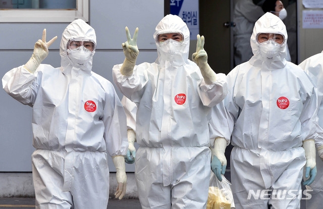 9일 오후 신종 코로나바이러스 감염증(코로나19) 지역거점병원인 계명대학교 대구동산병원에서 근무 교대를 위해 방호복을 착용한 의료진이 병동으로 들어서며 ‘브이(V)’자를 그려 보이고 있다.