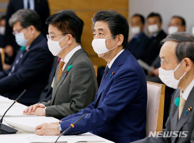 아베 신조 일본 총리가 16일 도쿄 관저에서 신종 코로나바이러스 감염증(코로나19) 대책위원회 회의에 참석해 마스크를 쓴 채 연설하고 있다. 아베 총리는 코로나19가 계속 확산하자 기존 7개 도부현에 발령했던 긴급사태를 전국으로 확대했다.