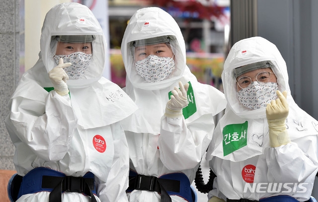 19일 오후 신종 코로나바이러스 감염증(코로나19) 지역거점병원인 계명대학교 대구동산병원에서 근무 교대를 위해 방호복을 착용한 의료진이 병동으로 들어서며 밝은 표정으로 손 하트를 만들어 보이고 있다.