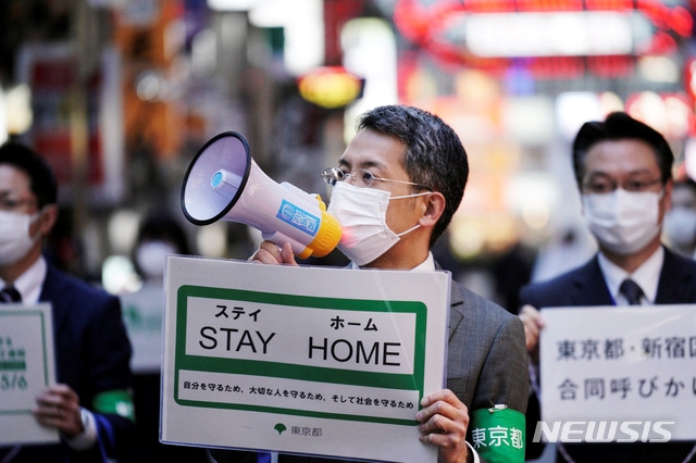 지난 24일 금요일 저녁 일본 도쿄 번화가 신주쿠에 위치한 유흥가 가부키쵸 길거리에서 도쿄도청 직원들이 "STAY HOME(집에 머물라)"라는 플래카드를 들고 확성기를 통해 신종 코로나바이러스 감염증(코로나19) 예방을 위해 귀가를 촉구하고 있다.