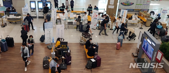 신종코로나바이러스 감염증(코로나 19) 사태가 국내에서 확산된지 100일을 하루 앞둔 27일 오전 인천공항 제1여객터미널 입국장에서 해외 입국자들이 각 지역으로 가는 입국자 전용 버스에 탑승하기 위해 대기를 하고 있다.