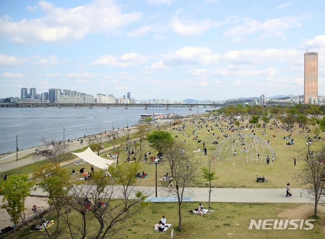 신종코로나바이러스 감염증(코로나19) 국내 일일 신규확진자가 10명대로 줄어든 지난 18일 오후 서울 영등포구 여의도 한강공원에 시민들이 돗자리를 깔고 여가시간을 보내고 있다.