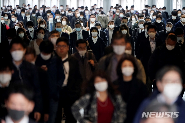 지난달 27일 일본 도쿄의 한 지하철 역에 신종 코로나바이러스 감염증(코로나19) 예방을 위해 마스크를 쓴 시민들이 걸어가고 있다.