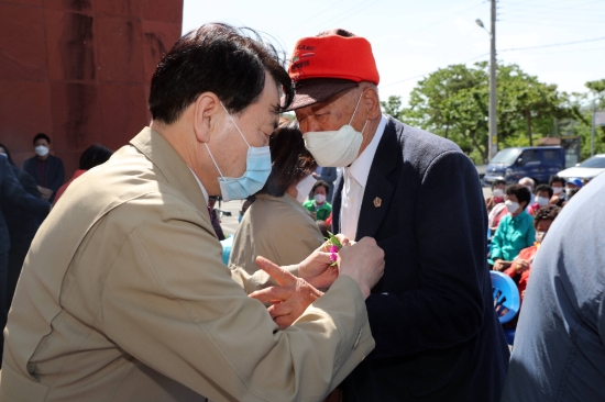 정종순 장흥군수가 ‘행복을 주는 어르신 안심 공경의 날’ 행사에서 어르신에게 카네이션을 달아주고 있다.이날 여성친화도시모니터단은 90여명의 어르신들에게 카네이션과 정성들여 준비한 선물꾸러미를 전달하고, 어버이 은혜에 감사하는 마음을 담아 합창을 하여 어르신들에게 감동을 드렸다./사진=장흥군