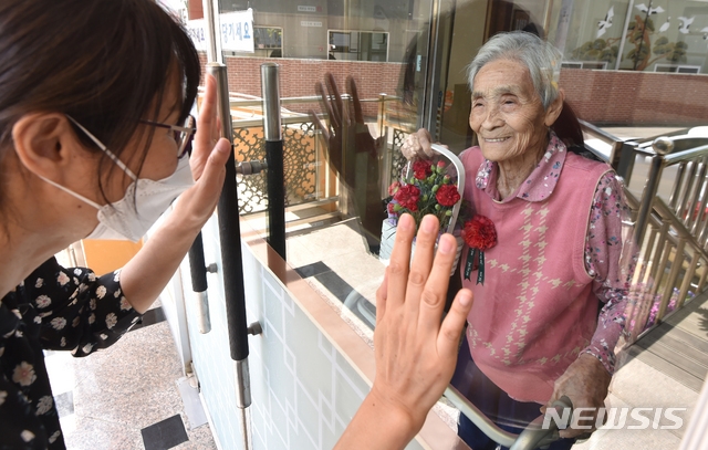 어버이날을 하루 앞둔 지난 7일 오후 경기 수원시 장안구 한 요양원에서 가족이 유리창 넘어로 면회하고 있다.