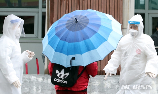 비 내리는 15일 오전 인천시 미추홀구 보건소 선별진료소에서 의료진들이 신종 코로나바이러스 감염증(코로나19) 검사를 하기 위해 방문한 시민을 안내하고 있다.