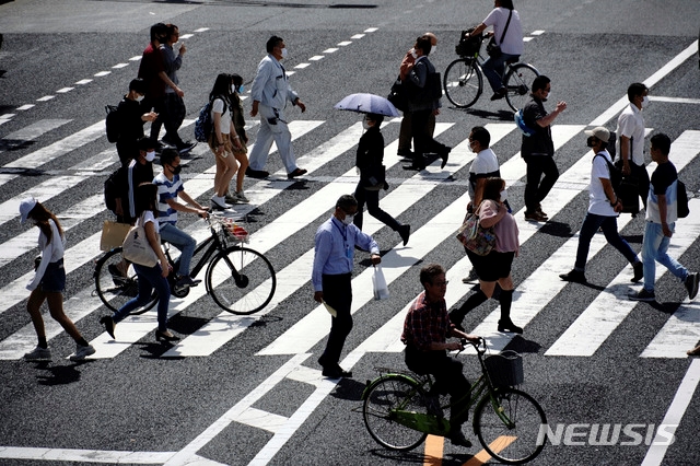 지난 15일 일본 도쿄의 한 횡단보도를 마스크를 쓴 시민들이 건너고 있다. 일본 정부는 지난 14일 전국 47개 지역 가운데 39개 지역에서 신종 코로나바이러스 감염증(코로나19) 예방을 위해 발령했던 긴급사태 선언을 해제했다.