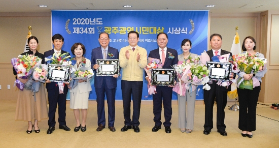 이용섭 광주광역시장이 21일 오전 시청 3층 비즈니스룸에서 열린 ‘2020년도 제34회 광주광역시민대상 시상식’에 참석해 상패를 수여한 뒤 수상자들과 함께 기념촬영을 하고 있다./사진=광주광역시