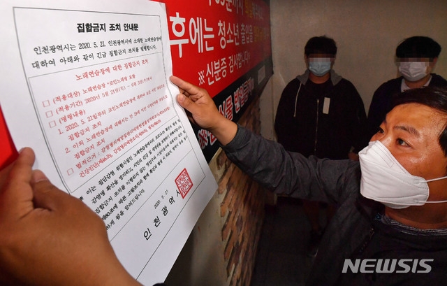 인천시가 신종 코로나바이러스 감염증(코로나19) 확산 방지를 위해 코인노래방에 2주간 집합금지 조치를 내린 가운데 21일 오후 인천시 부평구의 한 코인노래방에서 공무원이 집합금지 안내문을 부착하고 있다.