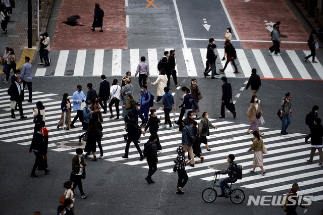 지난 22일 일본 도쿄에서 마스크를 쓴 시민들이 횡단보도를 건너고 있다.
