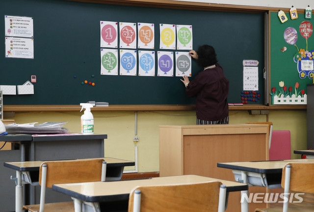 초등학교 1~2학년의 등교를 하루 앞둔 26일 오전 서울 양천구 계남초등학교에서 담임선생님이 학생들을 기다리며 칠판에 환영의 메시지를 부착하고 있다.