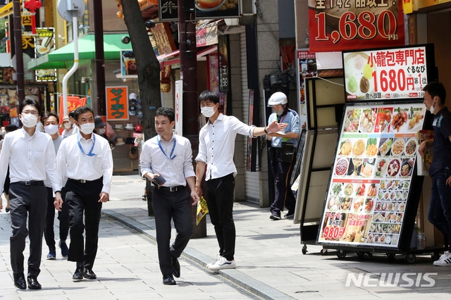 3일 일본 도쿄 인근 요코하마 차이나타운에서 신종 코로나바이러스 감염증(코로나19) 예방을 위해 마스크를 쓴 한 식장 직원(오른쪽 두 번째)이 호객행위를 하고 있다.