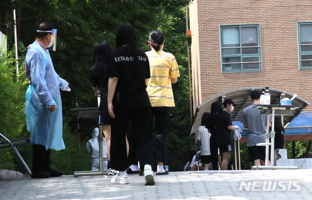 8일 오전 잠실 롯데월드를 방문한 뒤 신종 코로나바이러스 감염증(코로나19) 확진 판정을 받은 학생이 재학중인 서울 중랑구 원묵고등학교에 마련된 선별진료소로 학생들이 코로나19 진단검사를 받기 위해 들어가고 있다.