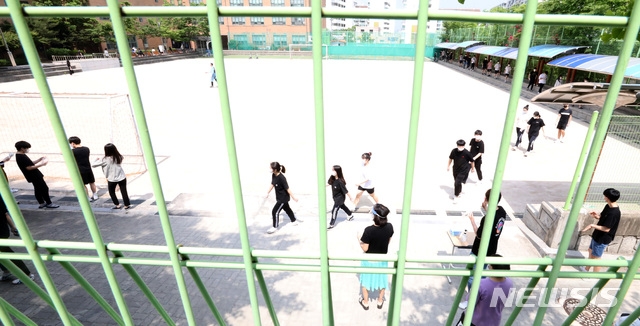 8일 오전 잠실 롯데월드를 방문한 뒤 신종 코로나바이러스 감염증(코로나19) 확진 판정을 받은 학생이 재학중인 서울 중랑구 원묵고등학교에 마련된 선별진료소로 학생들이 코로나19 진단검사를 받기 위해 들어가고 있다.